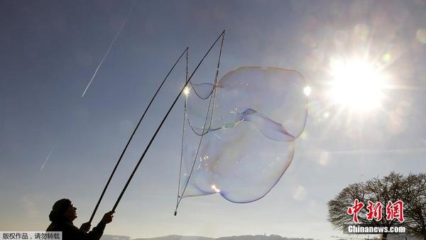 冬日阳光下吹泡泡 瑞士一男子制造巨型肥皂泡