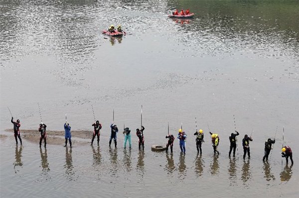 复兴空难现场第八天搜救行动，上午搜救人员一字排开拿棍子搜索。记者曾吉松/摄影（图片来源：台湾《联合晚报》）