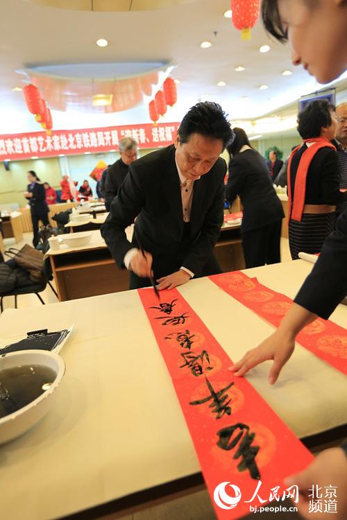 书法家写下吉祥喜庆的春联和“福”字。余荣华摄