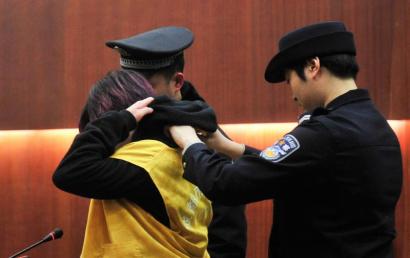 武侯区人民法院，被告手铐已经解开正在脱囚服，准备受审。