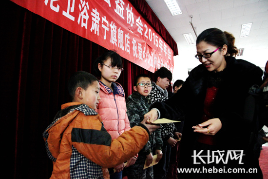 会员(右一)为特困学生颁发协会捐资。杨进涛 摄