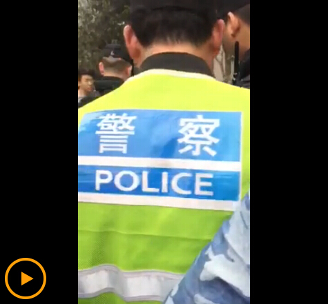 视频截图:围观人员有身穿制服的警察,但其并未阻止殴打行为