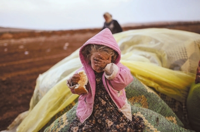 在桑利乌尔法省苏鲁奇镇，一个小女孩和母亲在难民营等待救援。