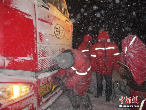 　　图为巴仑台公路管理分局救援队员用装载机拖拽一辆被困的大重型车辆。中新社发 伍雪梅 摄