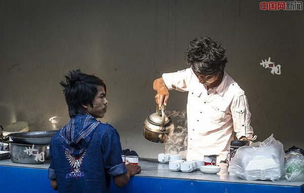 云南省瑞丽市德龙珠宝夜市上，两位年轻人正在倒咖啡。