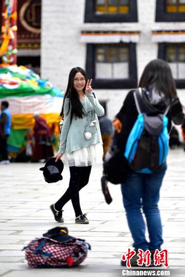 4月14日，游客在拉萨市大昭寺广场拍照留念。　李林　摄