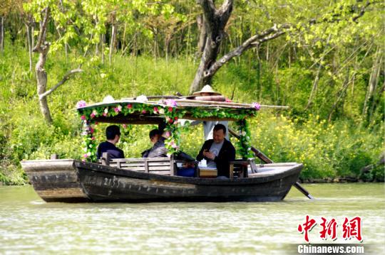 姜文等人乘坐西溪湿地内的电瓶船 西溪国家湿地公园供 摄