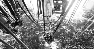 图为平台钻井工人正在安装水下防喷器控制电缆卡子。 赵 亮摄