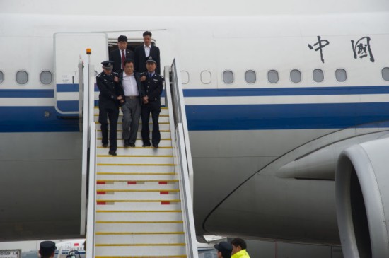 5月9日下午15时29分，涉嫌贪污职务犯罪潜逃新加坡的江西省鄱阳县财政局经济建设股原股长李华波被遣返回国，检察官和公安人员押解李华波走出机舱。