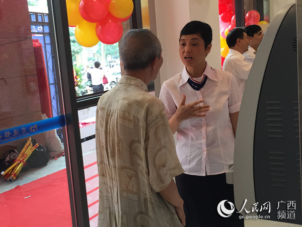 支行工作人员耐心地为老年人讲解指导如何使用自助机器