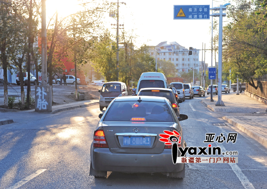 20日,在温泉东路“瓶颈”路段,大量的车辆在这里排着长队。亚心网首席记者张万德摄