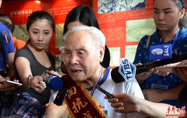 94岁的抗战老兵谭昆山被海峡两岸媒体记者团团围住。记者 龙腾 摄