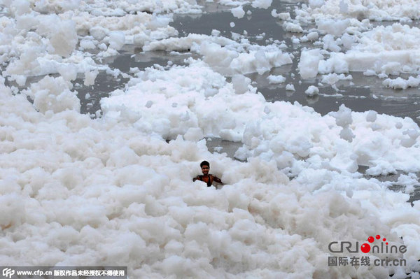当地时间2015年7月12日,印度诺伊达,亚穆纳河河岸泛起厚厚的泡沫。这主要是由于工业污染物排放在河里导致河水高氨含量。图片来源:CFP