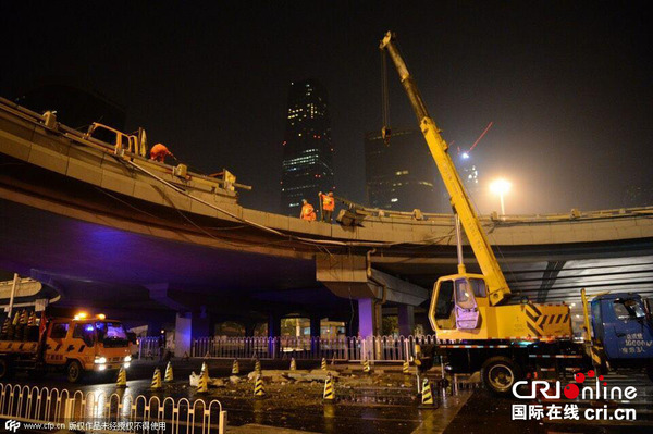 2015年7月16日，北京，一辆白色“路虎”汽车从国贸桥的西南角匝道桥坠落，未造成人员死亡。 车祸现场。图片来源：cfp