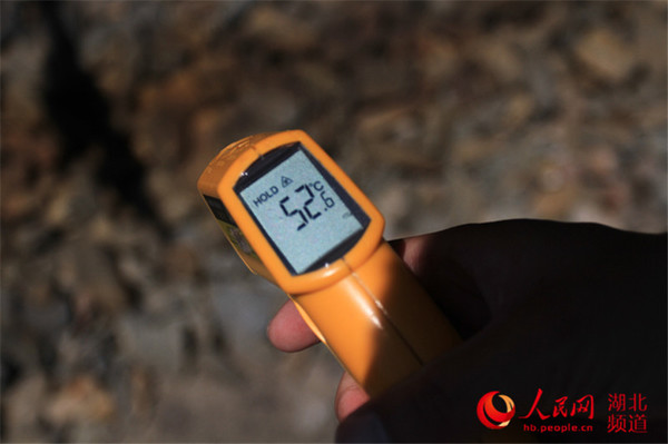 7月31日，12点20分，检车员用随身携带的点温计实测地表温度为52.6摄氏度。（刘卫兵 摄）