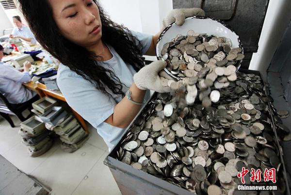 图为刚从钱箱里出来的零钱十分难清理。李风 摄