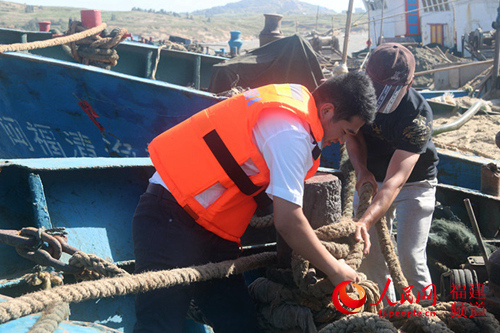海洋与渔业执法人员在福清市高山镇北垞鱼港帮渔民加固船只。 叶雨淋 摄