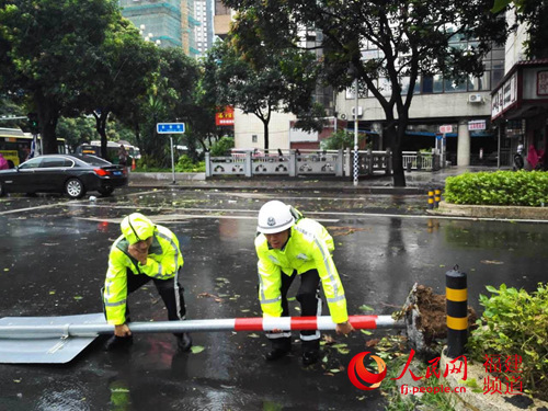 福州市鼓楼区永安街交通标牌被大风吹倒,交警在排除险情