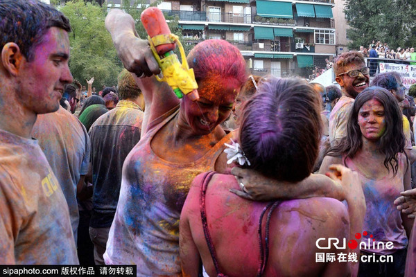 　　当地时间2015年8月8日，西班牙马德里，马德里民众街头欢度酒红节（Holi Festival），5000民众狂撒500公斤彩色粉末，新鲜花瓣来庆祝这一节日。图片来源：sipaphoto