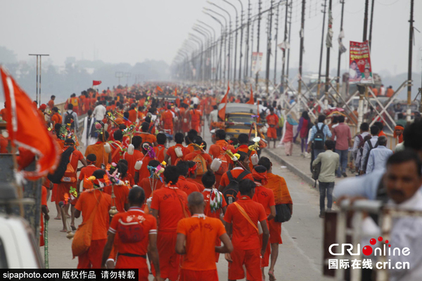 　　当地时间2015年8月10日，印度阿拉哈巴德，印度信徒“kanwarias”在前往金庙（Kashi Vishvanath temple）朝拜前在恒河将他们的壶灌满水。图片来源：SipaPhoto