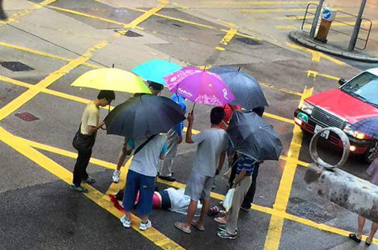 六名香港热心市民替伤者打伞。图自香港《大公报》