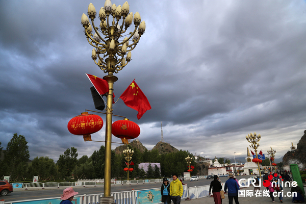 鲜艳的五星红旗在布达拉宫前的长街上飘扬。摄影：张攀