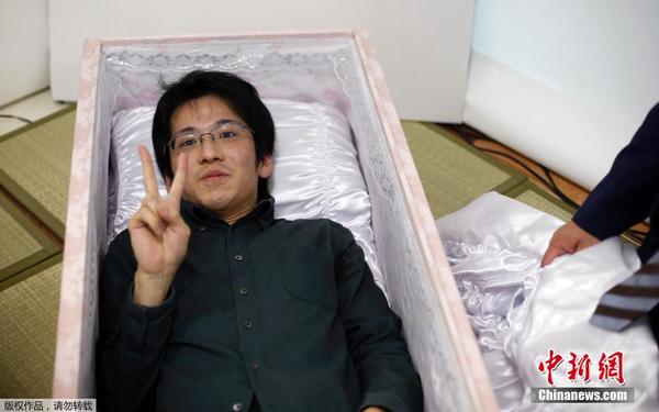 资料图片：当地时间2014年10月24日，日本葬礼行业提供超前服务，民众可以试穿寿衣，试躺棺材，拍遗照等殡葬服务。