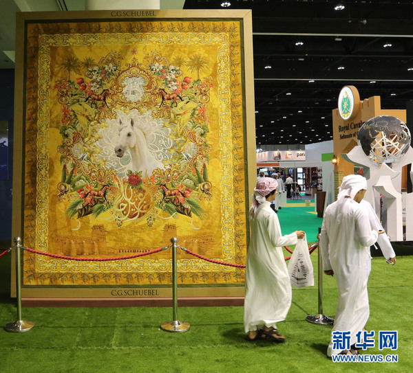 几名阿联酋男子从一幅巨大的丝绣骏马图挂毯前走过。新华社记者安江 摄