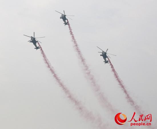 直-10武装直升机正在表演“三机跃升倒转”特技动作。闫嘉琪 摄
