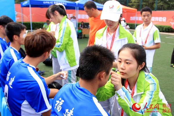 志愿者为福建运动员贴上眼贴。朱丽仙 摄