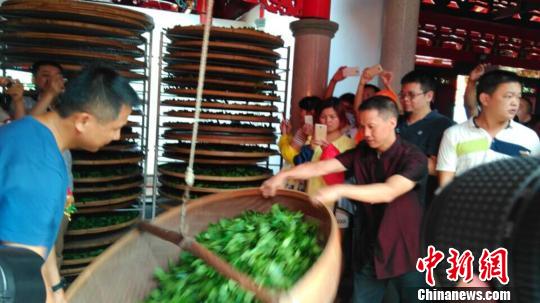 图为现场嘉宾体验制茶工艺流程。 廖静 摄