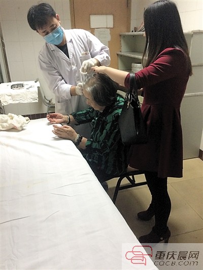 红衣女孩谭家莉一直守在婆婆身边。 重庆晨报记者 张旭 摄