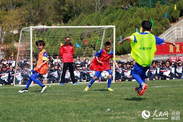 10月30日下午，云南泸西县在泸源中学举行全国青少年校园足球试点县建设启动仪式。图为少儿球员在启动仪式赛场上奋力拼抢。（人民网 李发兴 摄）