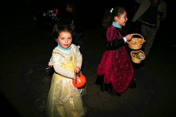 　　图为在墨西哥城提着南瓜小篮子，挨家挨户去要糖的两小女孩。