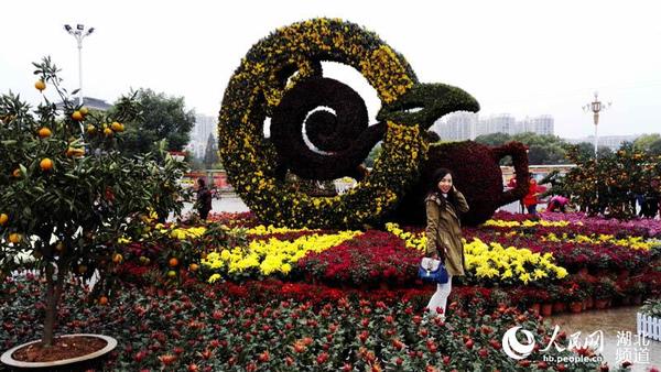 游客在巨大的扎花造型“桔都茶乡”前留影
