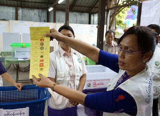 　　11月8日，在缅甸仰光，一名工作人员在投票站展示一张选票， 吴哥当摄