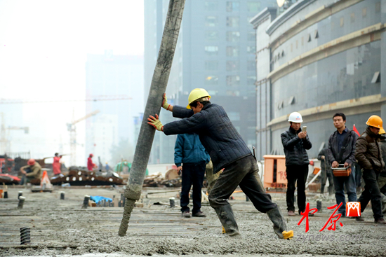 工人正在浇筑混凝土，预计14日夜间完成最后一段的施工。