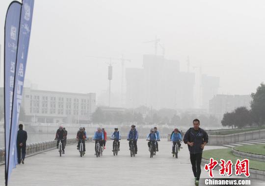 天津百余大学生雾霾中骑行倡低碳环保、绿色