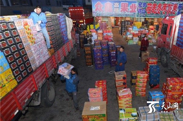 11月22日，在新疆库尔勒市巴音水果批发市场，来自外地的水果商人在批发应季水果。