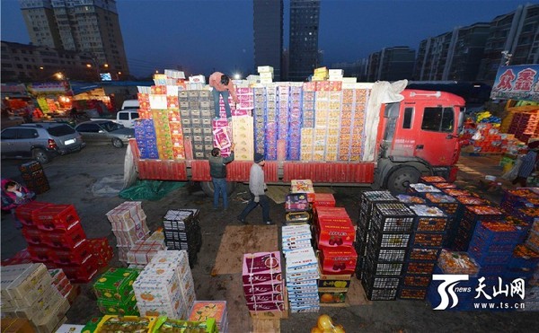 11月22日,在新疆库尔勒市巴音水果批发市场,来自外地的水果商人在批发应季水果。