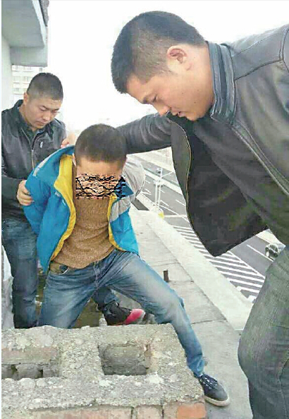 民警在楼顶抓获李华（中）图由警方提供