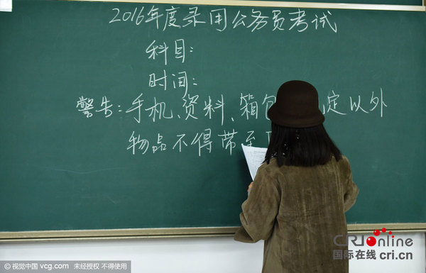 2015年11月29日，浙江省杭州市，在2016年国家公务员考试杭州一考点，监考人员在书写注意事项。图片来源:龙巍/视觉中国