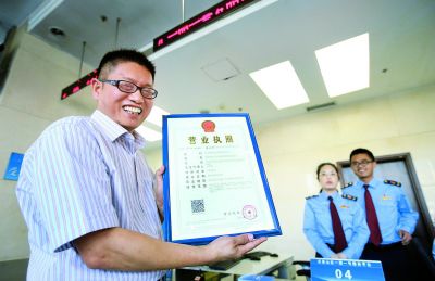 一名企业负责人在石景山工商分局领到北京首张“三证合一、一照一号”营业执照。（资料图）