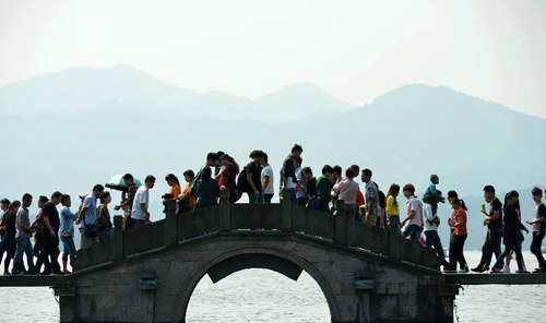今年十一黄金周，游客在杭州西湖栈桥上游览。（资料图）