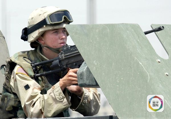 　　2003年6月13日，伊拉克摩苏尔，一名美军女兵手持一支机关枪。（图片来源：新华／法新）