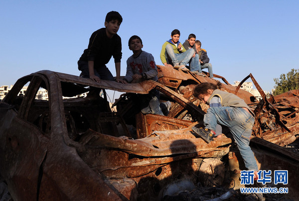 2015年12月7日，在叙利亚首都大马士革贾拉曼纳镇，一名女孩爬上一辆废旧汽车。