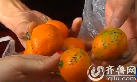 陈女士发现橘子皮上布满了虫子一样的黑斑。（视频截图）