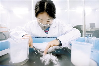 纤维检验专业人员在检测羽绒服的羽绒含量。 本报记者 胡杰 摄