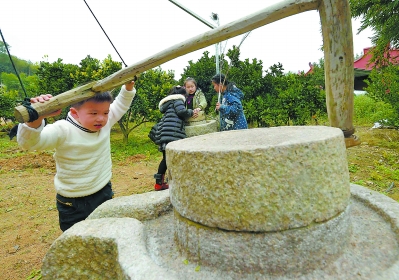 小游客正饶有兴致地体验推磨劳作。旧日农家的生活方式，对于今天的孩子来说，已经成为遥远的童话。只有遗留的一些旧物什，扩展着孩子们关于过去的想象……