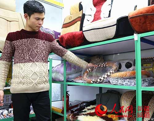 张腾飞在洗车店里展示自己的小汽车配套设备。（摄于12月7日）